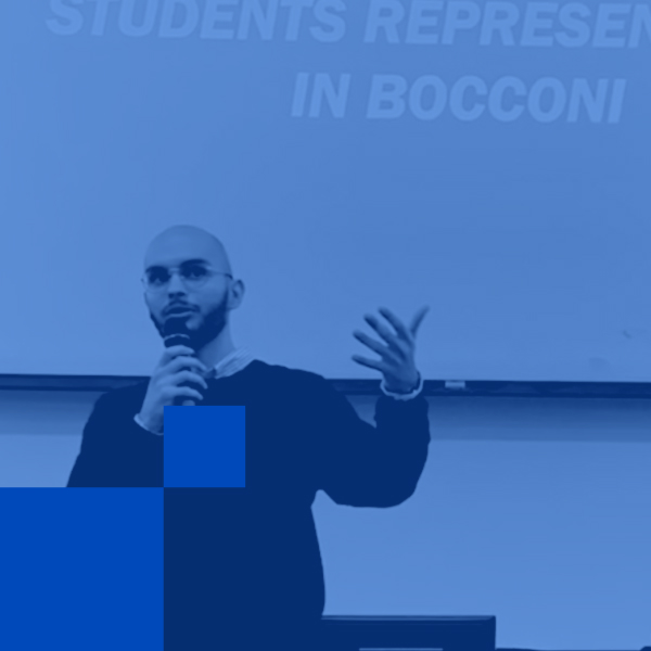 Achraf Fadhel parla al microfono durante un incontro in Bocconi